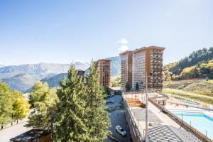 a view of a city with a pool and buildings at Notre Petite Famille - Station Le Corbier in Villarembert