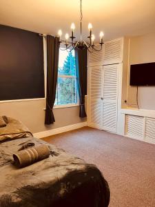 ein Schlafzimmer mit einem großen Bett und einem großen Fenster in der Unterkunft Stylish & Spacious Victorian Home near Severn Valley Railway & Safari Park in Kidderminster