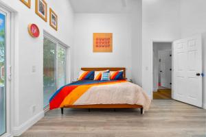 ein Schlafzimmer mit einem Bett mit einer bunten Bettdecke in der Unterkunft 6br Sleeps 21 Tropical Villa Heated Pool Hot Tub in Cedar Hammock + 75 Fotos