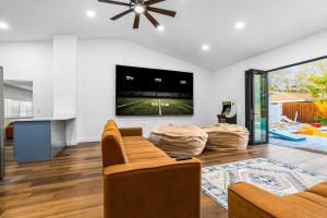 ein Wohnzimmer mit Couch und Flachbildfernseher in der Unterkunft 6br Sleeps 21 Tropical Villa Heated Pool Hot Tub in Cedar Hammock