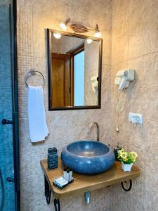 a bathroom with a large blue sink and a mirror at Hotel Fjor in Prizren