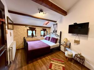 a bedroom with a bed and a flat screen tv at Hotel Fjor in Prizren