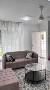 a living room with a couch and a glass table at Anggun's palace in Pasir Gudang