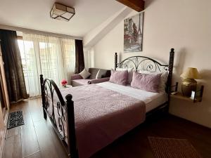 a bedroom with a large bed and a couch at Hotel Fjor in Prizren