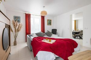 a bedroom with a bed with a red blanket at La Rochoise - Parking, Wifi, proche Fontainebleau in La Grande-Paroisse