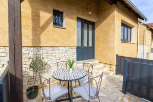 a patio with a table and chairs in front of a building at La Gardère - Villa Sarlat in Sarlat-la-Canéda