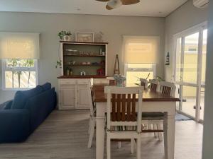 eine Küche mit einem Tisch und Stühlen sowie einem blauen Sofa in der Unterkunft Refúgio em Juquehy no centro a poucos metros do mar com piscina privativa aquecida in São Sebastião