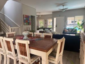 ein Esstisch und Stühle in einem Wohnzimmer in der Unterkunft Refúgio em Juquehy no centro a poucos metros do mar com piscina privativa aquecida in São Sebastião