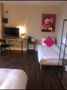 a bedroom with a bed and a desk with a laptop at izzy hotel ltd in Old Walker