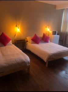 a bedroom with two beds with red pillows at izzy hotel ltd in Old Walker