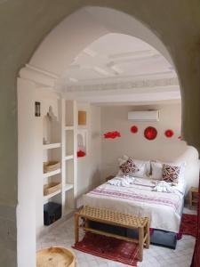 a bedroom with a bed and a bench in a room at Riad Le Bijou de Zahra Marrakech Kasbah in Marrakech