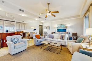 a living room with couches and chairs and a kitchen at Sunset Retreat in Panama City Beach