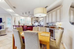 a kitchen and dining room with a wooden table and chairs at Sunset Retreat in Panama City Beach