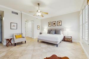 a bedroom with a bed and a chair and a ceiling fan at Sunset Retreat in Panama City Beach +37 photos
