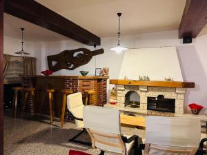 a living room with chairs and a stone fireplace at Pensiunea Casa Ancutei in Ranca