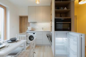 a kitchen with white cabinets and a washer and dryer at Môj Hillside in Dolný Kubín +25 photos