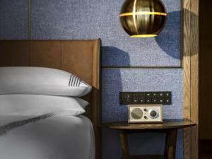 een slaapkamer met een bed en een klok op een nachtkastje bij Thompson Shanghai Expo in Shanghai +25 foto's