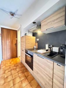 a kitchen with wooden cabinets and a counter top at Alpine stay at the foot of the slopes in Crest-Voland +15 photos