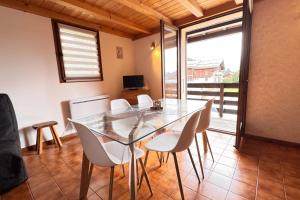 a dining room with a glass table and white chairs at Alpine stay at the foot of the slopes in Crest-Voland