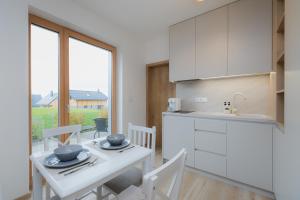 a kitchen with a table with chairs and a white counter at Môj Hillside in Dolný Kubín