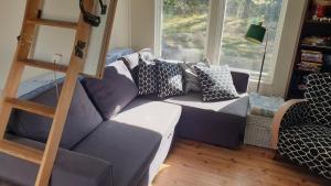 sala de estar con sofá púrpura y escalera en Spersboda 2 barnvänliga hus sjöutsikt & VARM pool Spersboda, en Spersboda