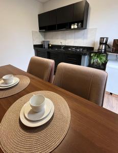 a dining room table with two cups and plates on it at Studio aconchegante e tranquilo! Perto de tudo! in Indaial