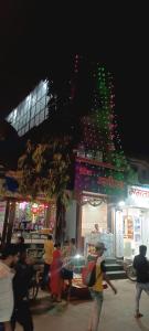 un grupo de personas de pie fuera de una tienda por la noche en Hotel Bhagirath, en Bombay 13 fotos más