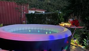 a large hot tub in a backyard with a table at Rehobot MountainView-Hidden Rainforest Gem in Rio Grande