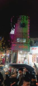 Un grupo de personas caminando por una calle de la ciudad por la noche. en Hotel Bhagirath, en Bombay
