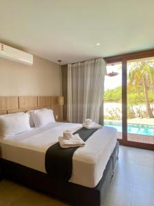 阿廷斯Refúgio do Igarapé - Luxo, Conforto & Piscina的卧室里有一张大床,床上铺着毛巾。