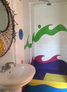 een badkamer met een wastafel en een golf op de muur geschilderd bij wKd bEach loFts THuNDER bAy Colourful in Saint James