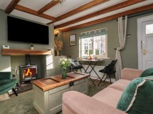 ein Wohnzimmer mit Kamin und Fernseher in der Unterkunft Chimes Cottage in Guisborough
