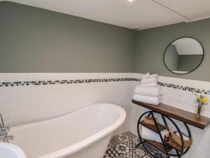 ein Badezimmer mit Badewanne, Waschbecken und Spiegel in der Unterkunft Chimes Cottage in Guisborough + 27 Fotos