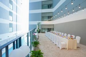 a long table with white chairs in a building at Panorama Sky Beach Recidences in Nha Trang +39 photos