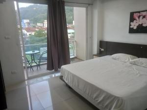 een slaapkamer met een bed en een balkon met een tafel bij Lucky3star in Patong Beach