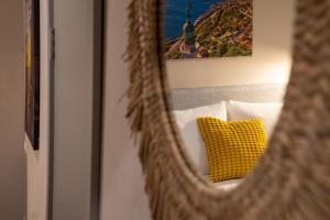 a mirror reflecting a yellow pillow on a bed at Sette Vele Rooms in Trieste