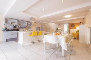 een keuken en eetkamer met een tafel en gele stoelen bij La Coloc - Chatillon la Palud idéal PROS in Châtillon-la-Palud