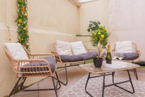 een terras met rieten stoelen en een tafel met een wijnglas bij La Coloc - Chatillon la Palud idéal PROS in Châtillon-la-Palud