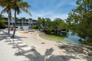 a group of lounge chairs on a beach at Saltwater Lagoon Front View, Marina, Kayaks in Key Largo