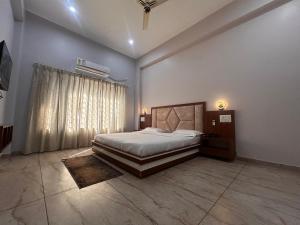 a bedroom with a large bed and a window at The Satluj Vista in Bilāspur