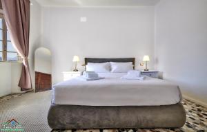 a bedroom with a large white bed with two lamps at Villa Scoglio with Private Hot Tub and Air Conditioning in Lierna