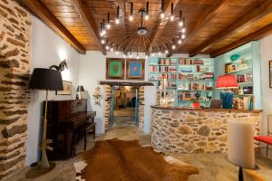 sala de estar con chimenea de piedra y lámpara de araña. en Αρχοντικό 1716, en Agios Lavredios