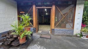 an open door of a house with potted plants at Grace Backwater Villa Coorg in Suntikoppa