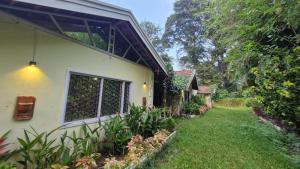 a house with a yard next to a building at Grace Backwater Villa Coorg in Suntikoppa