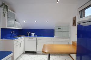 uma cozinha azul e branca com uma mesa de madeira em Hotel Mutter Buermann em Hemmingen mais 93 fotografias