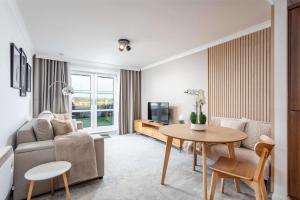 a living room with a couch and a table at Old Prestwick Point - Donnini Apartments in Prestwick
