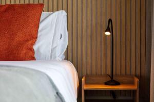 a bedroom with a bed and a lamp on a night stand at Old Prestwick Point - Donnini Apartments in Prestwick