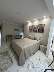 a bedroom with a large bed and a table at Apartamento grande em Santa Teresa-ES in Santa Teresa