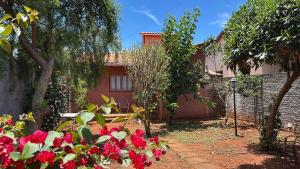 a garden with red flowers in front of a house at Casinha da Mila in Piatã