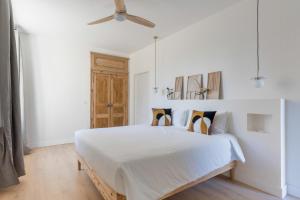 a white bedroom with a large bed with a ceiling at DOMAINE De PLAISANCE in Cachen